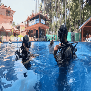 An instructor running a confined-water skill with a student in the pool